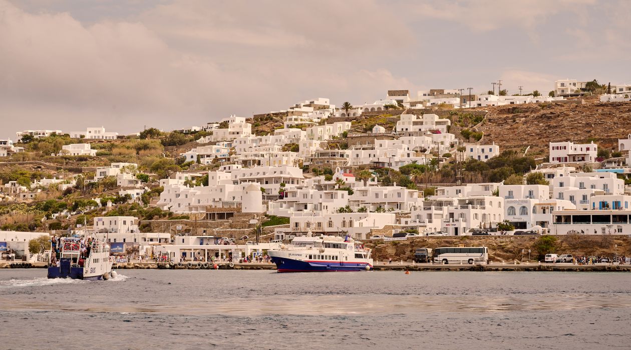 Ferries moored along a Greek island town harbour on the coast