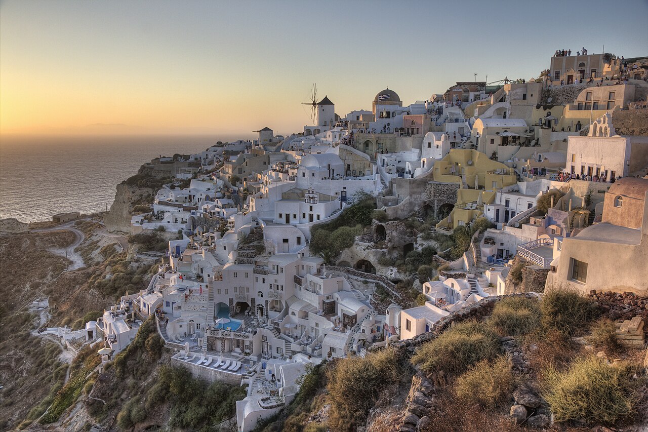 Oia village on the Santorini caldera with white houses and blue domes, Greece
